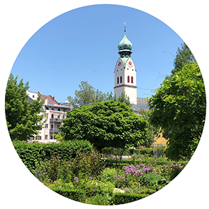 Ansicht vom grünen Riedergarten auf den Kirchturm.